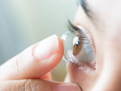 En kontaktlinse der er på vej ind i øjet