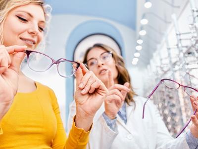 Billede af en kvinde som er i gang med at vælge nye briller hos optikeren