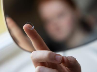 En kontaktlinse på en finger